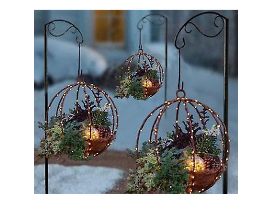 Cesta de Natal artificial suspensa com enfeites variados e luzes de LED.