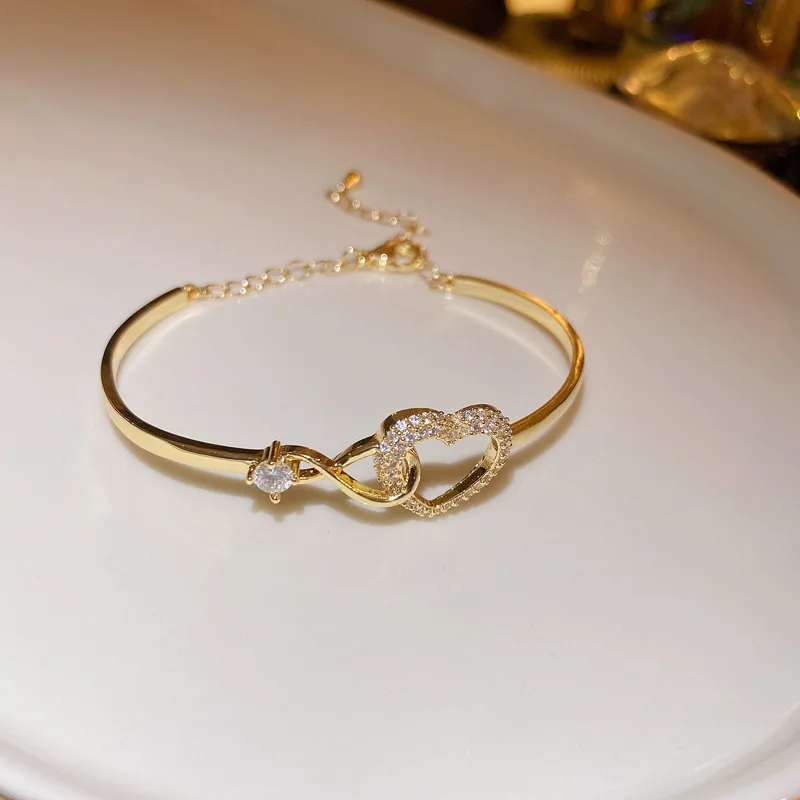 Pulseira Em Zircônia Vazada Em Formato De Coração (dourada), Com Design Simples E Elegante Em Tons Frios.